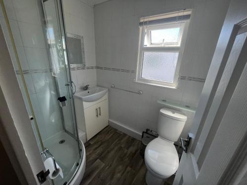 a bathroom with a toilet and a glass shower at Chalet 192, Hemsby - Two bed chalet, sleeps 5, pet friendly, bed linen and towels included in Hemsby