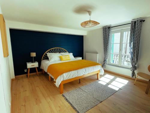 a bedroom with a bed with a blue wall at Amboise - L'écrin de Léonard in Amboise