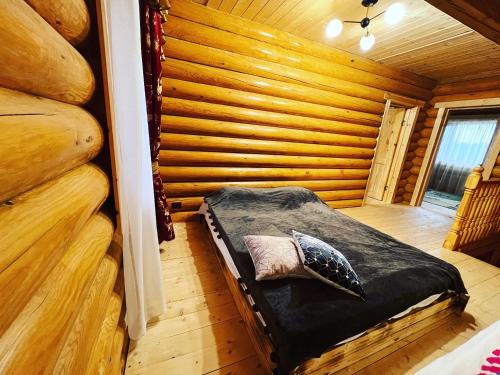 a bedroom with a bed in a log cabin at По Щучьему Велению in Shchūchīnsk