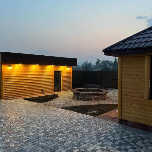 a wooden building with a fire pit in front of it at По Щучьему Велению in Shchūchīnsk