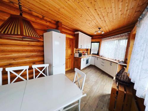 a kitchen with a white table and a white refrigerator at По Щучьему Велению in Shchūchīnsk
