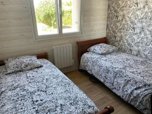 sypialnia z dwoma łóżkami i oknem w obiekcie Maison familiale et cosy w mieście Roscanvel