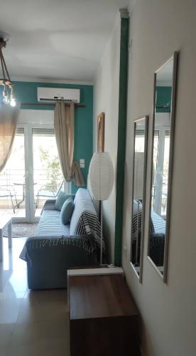 a living room with a bed and two mirrors at F.K Room 2 in Aigio