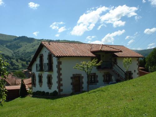 una casa en la cima de una colina verde en La Riguera De Ucieda, en Ucieda de Arriba