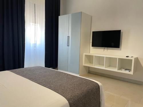 a bedroom with a bed and a cabinet with a television at Casa Kippis - Rifinito appartamento con posto auto in Taranto