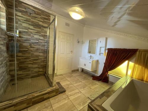 a bathroom with a shower and a sink at @Grace Guesthouse in Klerksdorp