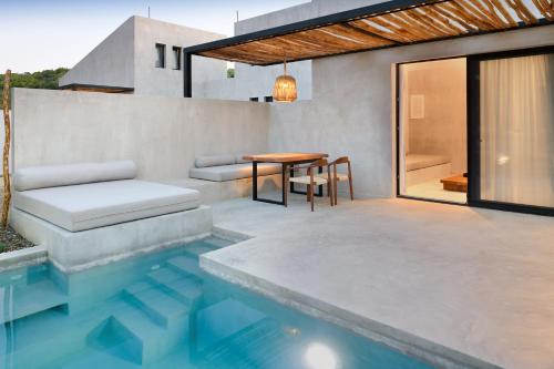 um pátio com uma mesa e uma piscina em Pure Villas em Ormos Panagias