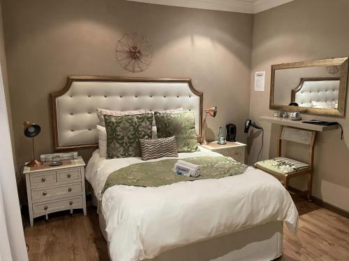 a bedroom with a large bed and a mirror at @Grace Guesthouse in Klerksdorp