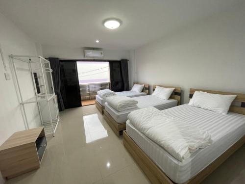 Khoksametchun Hostel Plus 2 في هات ياي: غرفة نوم بسريرين وتلفزيون فيها