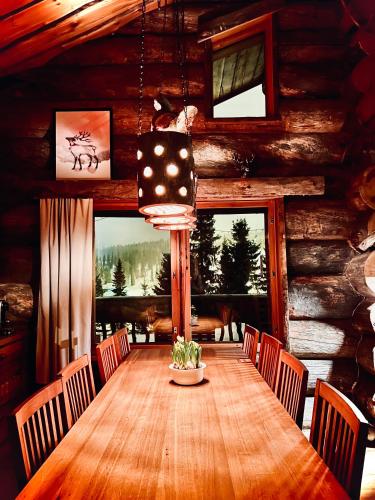 a dining room with a wooden table and chairs at Ruka View at the Slopes Ski in, Family & Bike Park, National Park, hike trails - Lapland Villas in Ruka