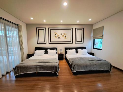 a bedroom with two beds and a large window at THE OASIS 4BR Private Pool Pet-Friendly Villa Vimala Hills in Gadok 1