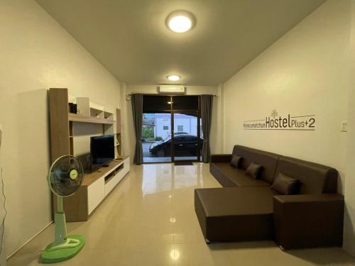 Khoksametchun Hostel Plus 2 في هات ياي: غرفة معيشة مع أريكة وتلفزيون