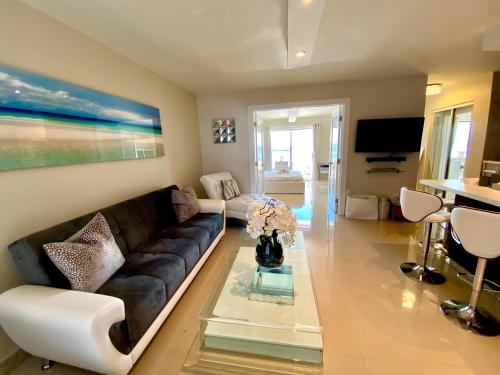 een woonkamer met een bank en een tafel bij Premium Modern waterfront apartment with Miami Skyline view on the bay 5 mins drive to Miami Beach with free parking in Miami Beach