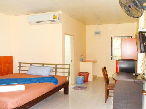 1 dormitorio con 1 cama, TV y silla en Bonus Bungalow, en Chalong 