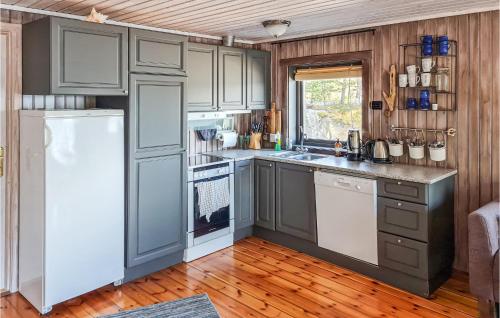 cocina con electrodomésticos blancos y suelo de madera en Nice Home In Lysysundet With Kitchen, 