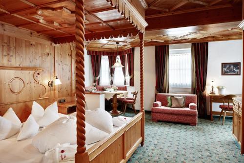1 dormitorio con cama con dosel y sala de estar. en Villa Angela en Mayrhofen