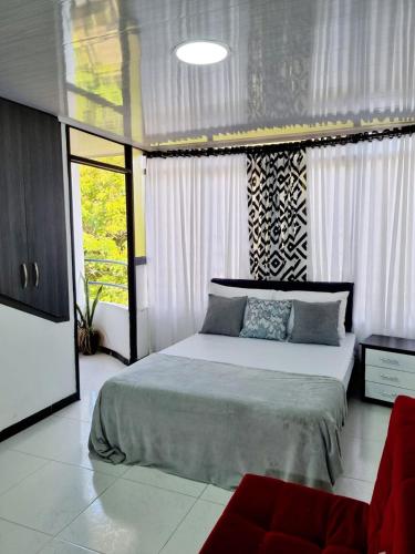- une chambre avec un grand lit et un canapé rouge dans l'établissement Apartaestudio ROMA 402 Edificio Europa Ibagué, à Ibagué