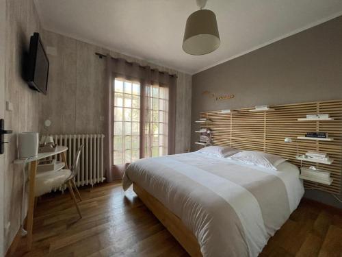 Schlafzimmer mit einem großen weißen Bett und einem Schreibtisch in der Unterkunft L'OLIU DE L'OUSTALET in Castelsarrasin