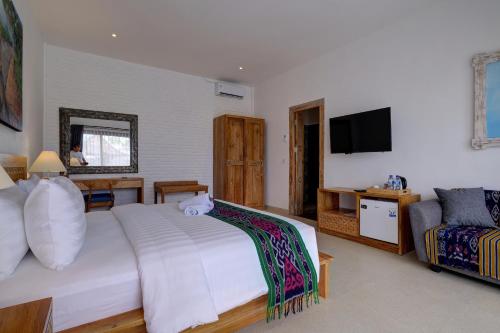 a bedroom with a bed and a tv and a couch at Wide Sands Beach Retreat in Pulukan