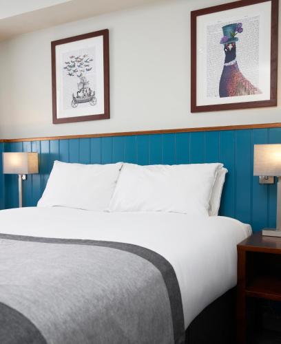 1 cama en una habitación de hotel con 2 cuadros en la pared en Highwayman By Greene King Inn, en Dunstable