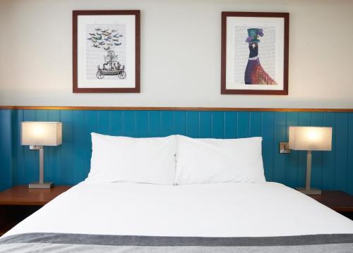 a bedroom with a large bed with two lamps at Highwayman Hotel in Dunstable