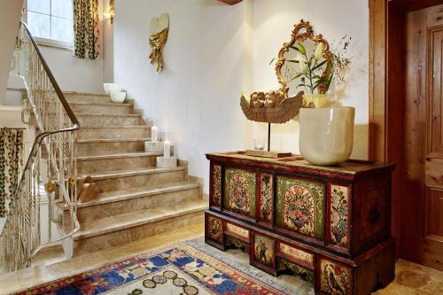 aoyer with a staircase with a wooden chest and a mirror at Villa Angela in Mayrhofen
