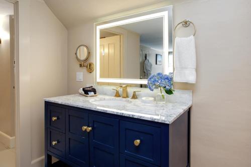 a bathroom with a blue sink and a mirror at Inn On Main in Yarmouth Port