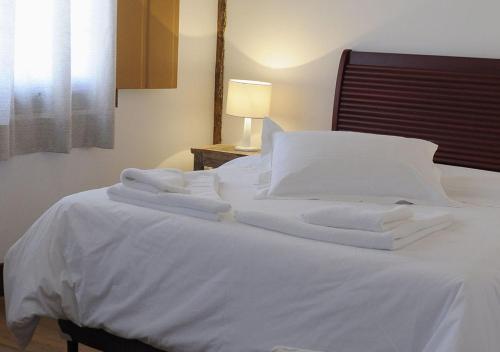 a white bed with white sheets and pillows on it at Pouso da Chica in Diamantina