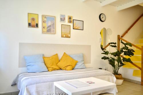 a bedroom with a bed with yellow pillows and a table at Loft Amarillo in Tandil