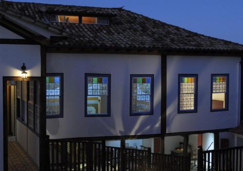 a white house with windows and a black fence at Pouso da Chica in Diamantina