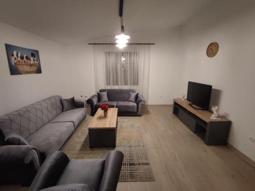 sala de estar con sofá y TV en Guest House Tomba, en Bar