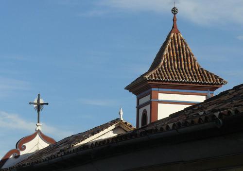 a church steeple with a cross on top of a building at Pouso da Chica in Diamantina