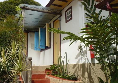 a house with a blue window and some plants at Pouso da Chica in Diamantina