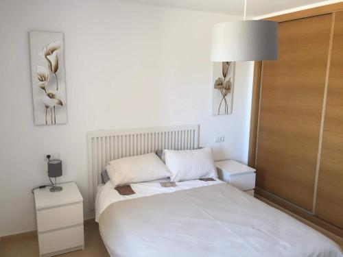 um quarto com uma cama branca e um candeeiro em Casa Moriarty em Múrcia
