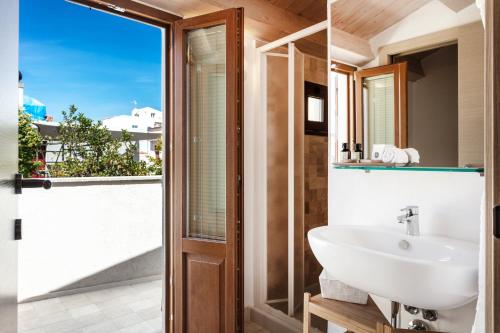a bathroom with a sink and a glass door at REEF Suites in Olbia