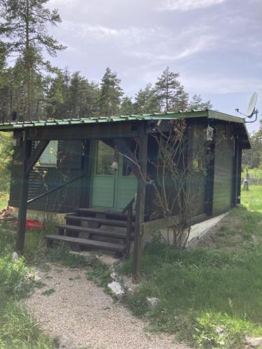 un pequeño cobertizo con un banco en un campo en Petit chalet pour amoureux de la nature au « Domaine de Tara » en Gréolières