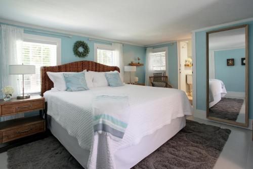 a bedroom with a large bed and a mirror at Inn On Main in Yarmouth Port
