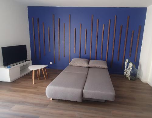 - une chambre avec un lit et un mur bleu dans l'établissement Résidence Prestige, Calme & Terrasse Ensoleillée, à Grenoble