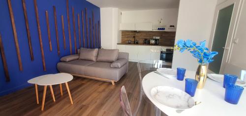 Résidence Prestige, Calme & Terrasse Ensoleillée في غرونوبل: غرفة معيشة مع أريكة وطاولة