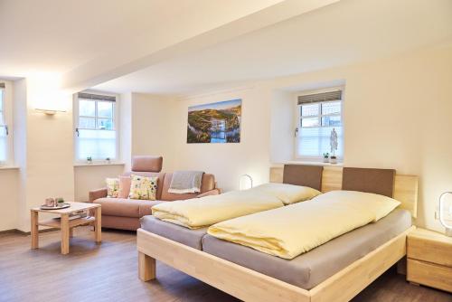 a bedroom with a bed and a couch at Ferienappartements Hermannshöhle in Niederhausen