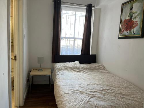 a small bedroom with a bed and a window at Safran House in London