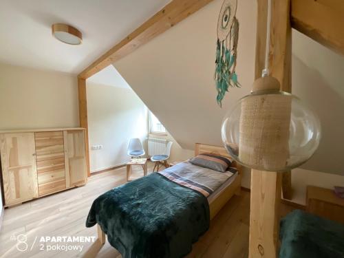 niewielka sypialnia z łóżkiem i schodami w obiekcie Apartament Karkonoska w Przesiece