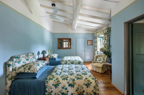 ein Schlafzimmer mit blauen Wänden und einem Bett und einem Sofa in der Unterkunft Villa Colonica Tuori at Tenuta Schifanoia in San Piero a Sieve