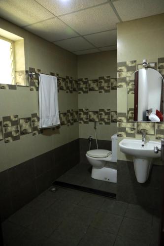 a bathroom with a sink and a toilet and a mirror at NIDHI RESIDENCY in Guruvāyūr