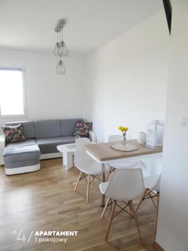 a living room with a couch and a table and chairs at Apartament Karkonoska in Przesieka