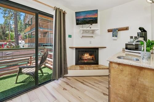 a kitchen with a fireplace next to a balcony at Big Bear Lake Front Lodge in Big Bear Lake
