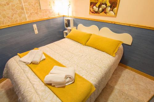 a large bed with yellow and white towels on it at Hostal El Cartero in Teruel