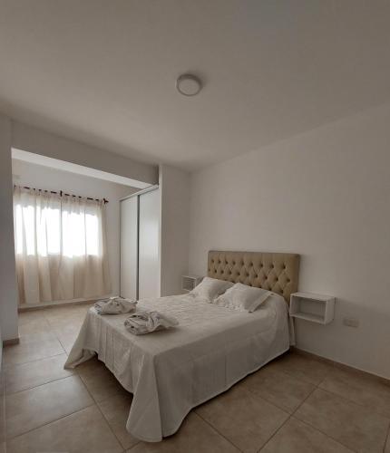 1 dormitorio con 1 cama grande en una habitación blanca en DUPLEX 2 en San Fernando del Valle de Catamarca