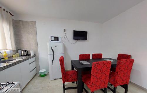 a kitchen with a black table and red chairs at DUPLEX 2 in San Fernando del Valle de Catamarca