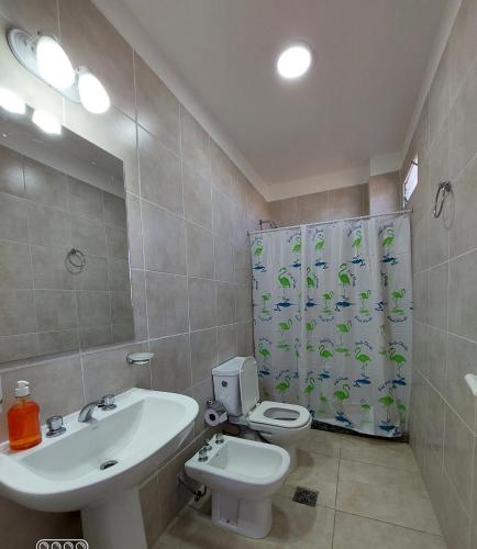 ein Badezimmer mit einem Waschbecken, einem WC und einem Duschvorhang in der Unterkunft DUPLEX 2 in San Fernando del Valle de Catamarca
